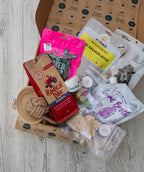 Assorted dog treats and products on a wooden surface with branded packaging.