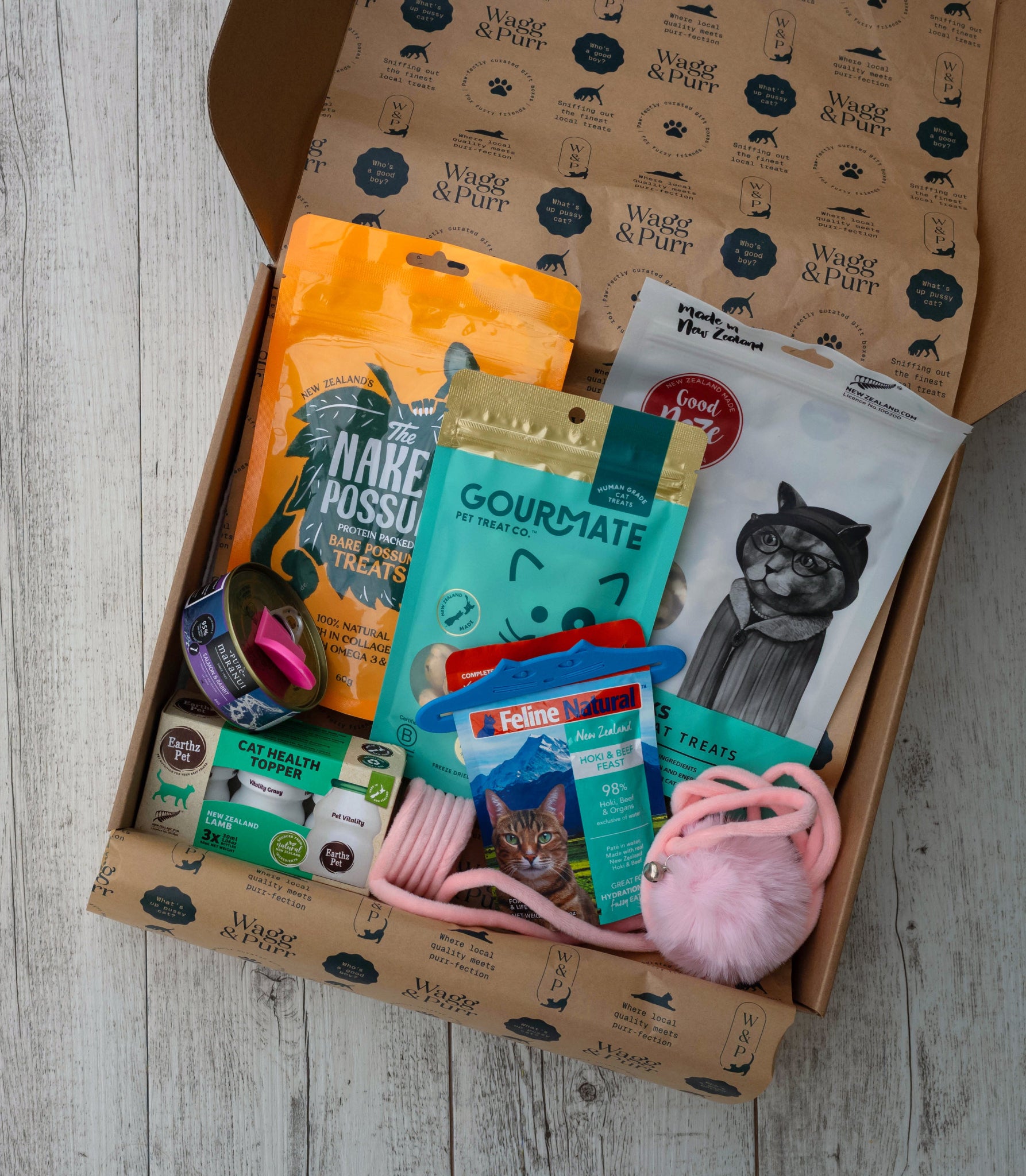 Cat care products in a box with visible branding on a wooden surface