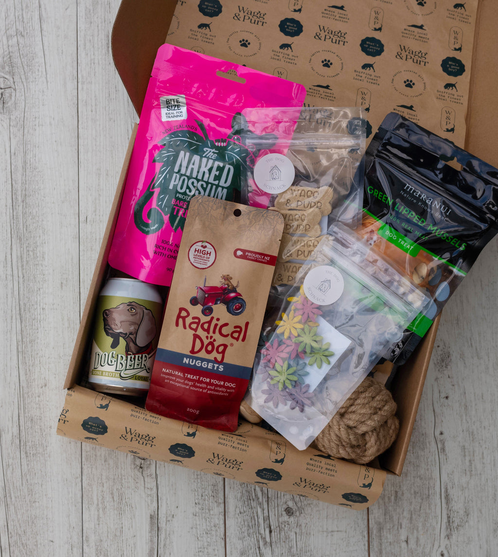 Dog treat and product box with various items on a wooden surface