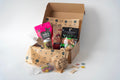 Dog product box with various dog treats and toys on a white background